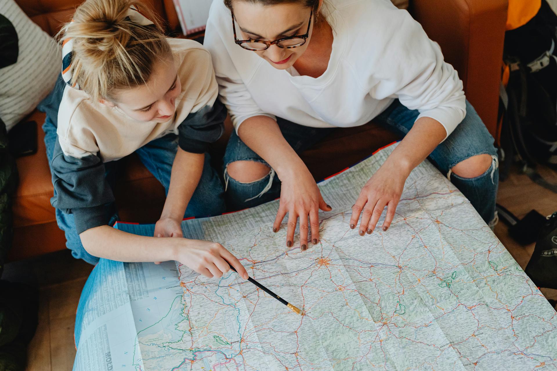 A Mother and Daughter Looking at a Map Planning Their Trip