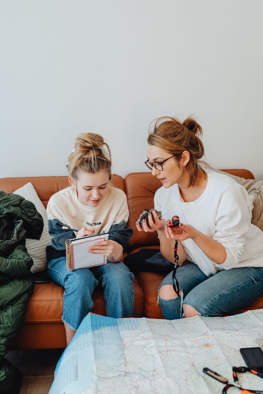 A mother and her daughter sitting together planning in a cosy living room