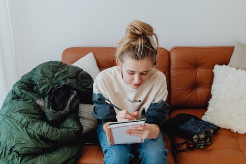 A Girl Writing on a Notebook