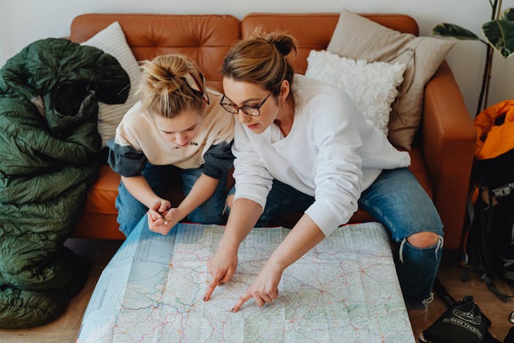 A Woman And A Girl Looking At The Paper Map