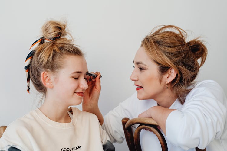 Woman Putting Makeup On Her Friend