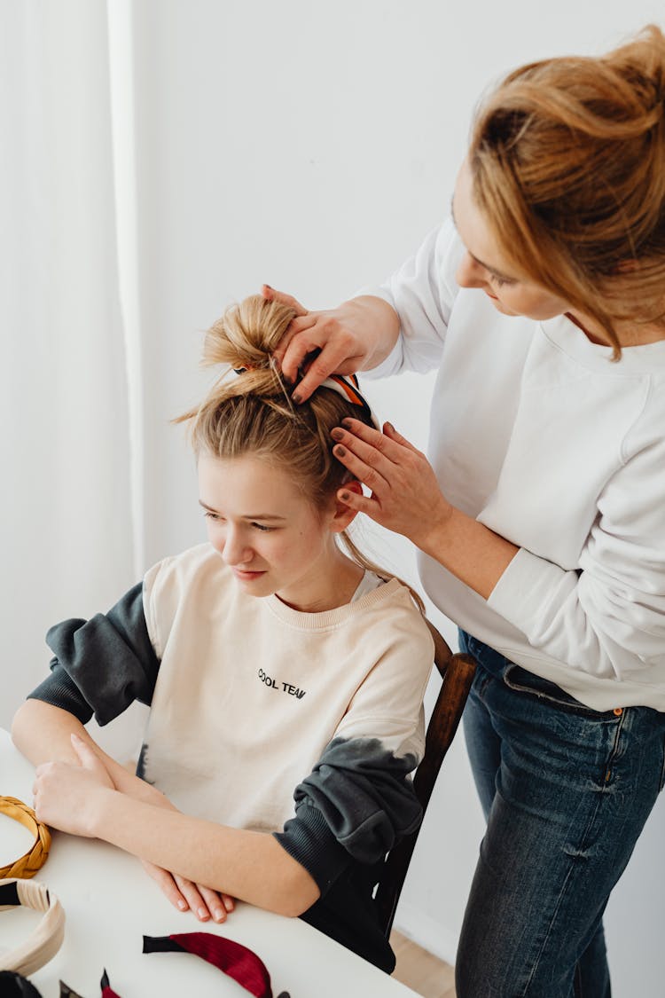 Woman Doing The Hair Of Her Daughter