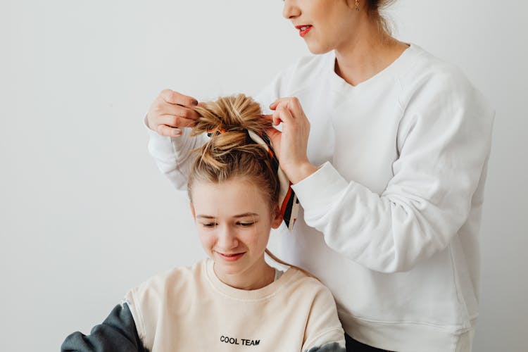 Woman Styling Her Daughters Hair