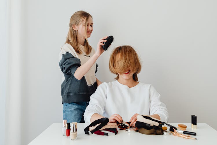 Smiling Girl Doing Hairstyle For Mother