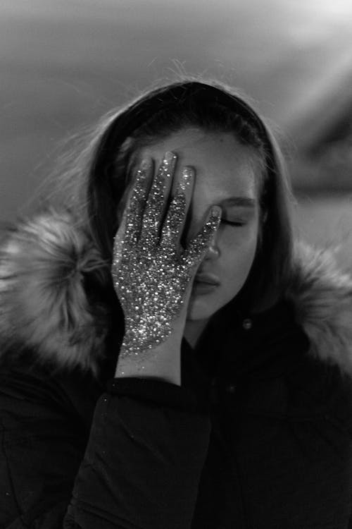 Woman Covering Her Face With Her Glitter Covered Hand