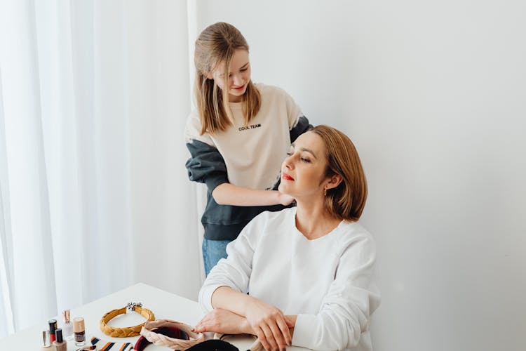 A Woman Putting Makeup On Another Woman