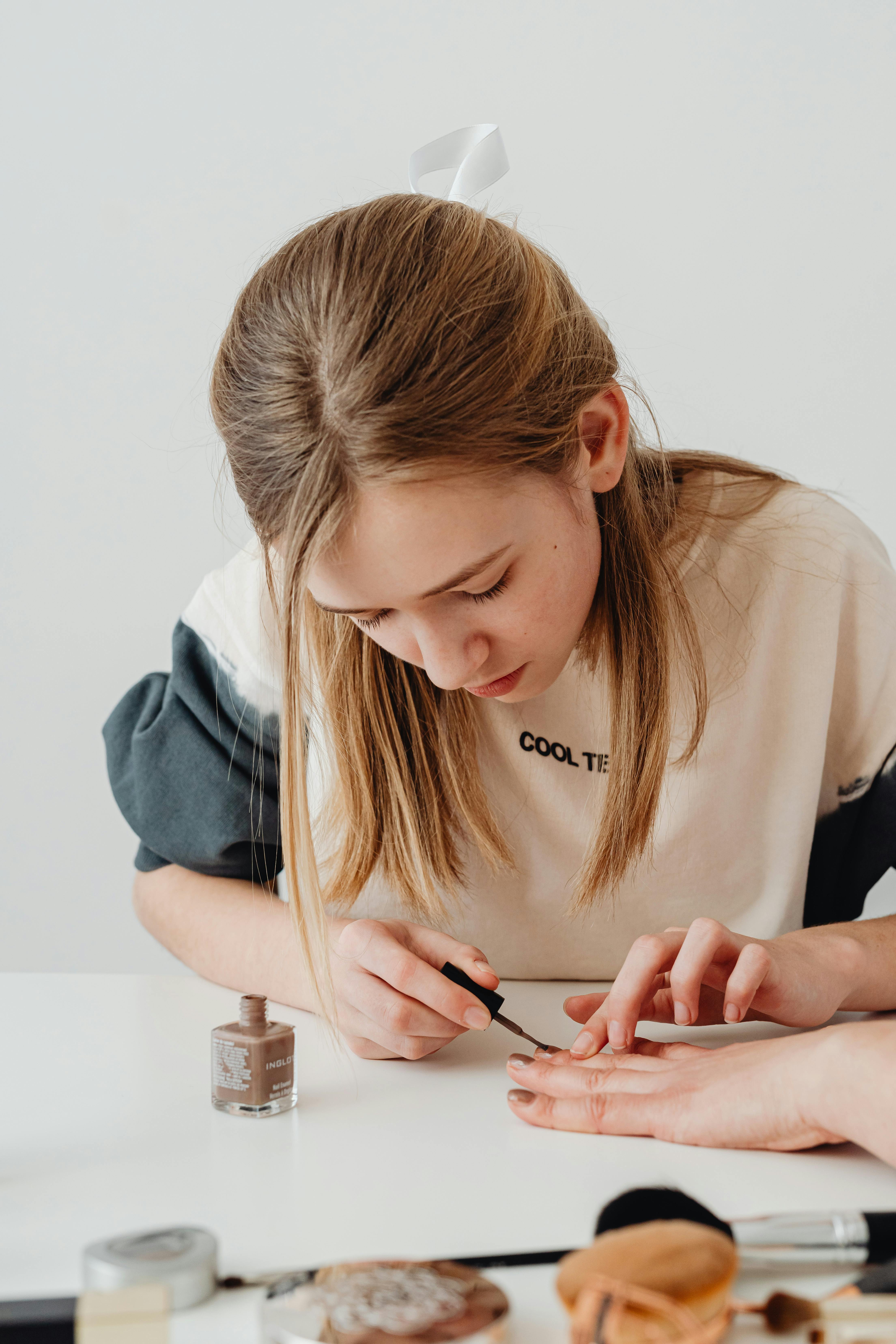 girl doing manicure with nail polish