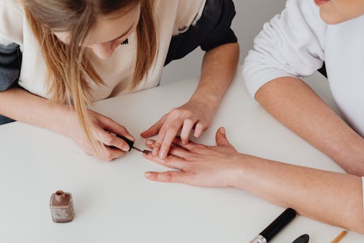 Close-up of a professional manicure being applied on a woman's hand at a salon.