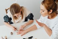 Woman in White Shirt Writing on White Paper