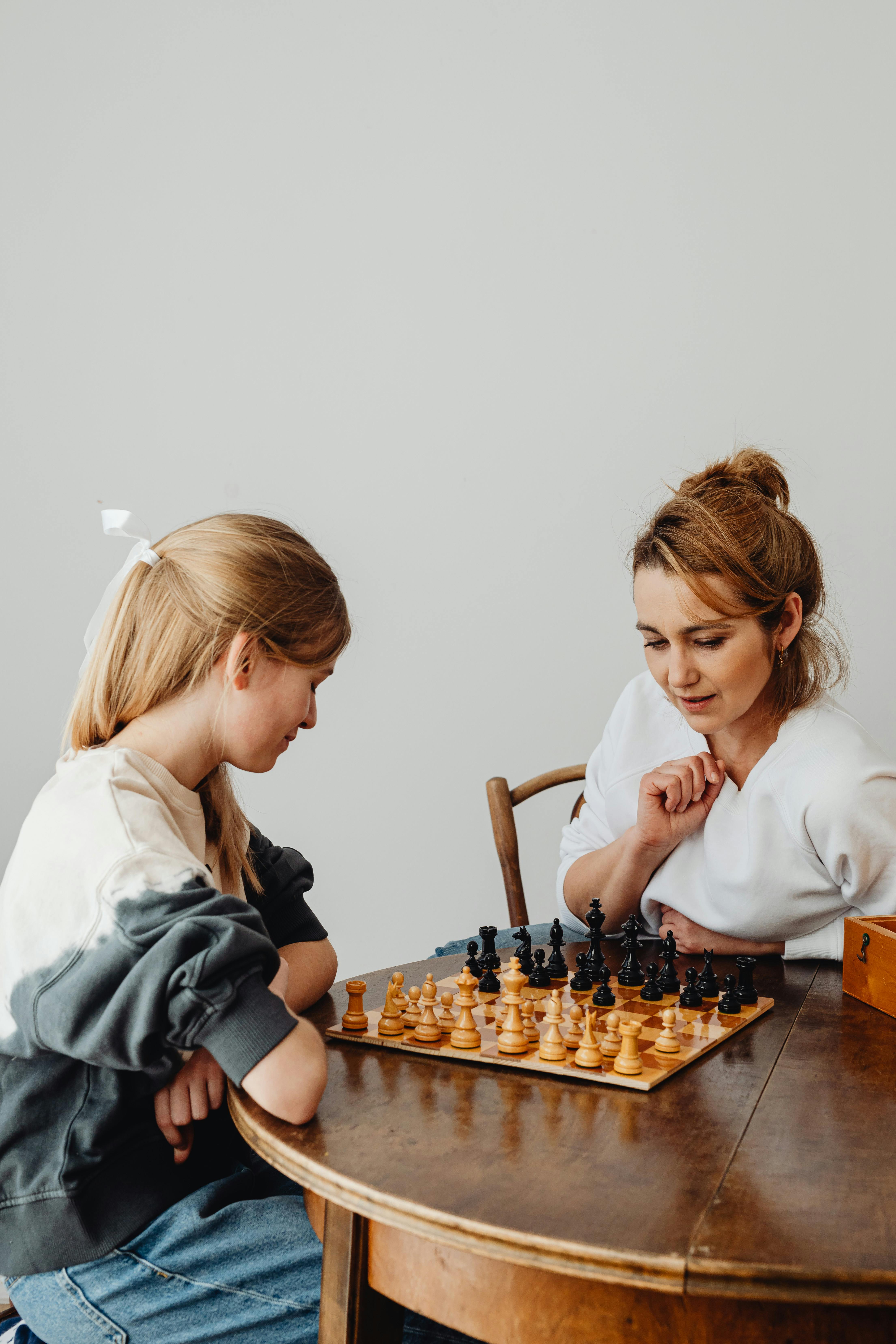 girl and a woman playing chess