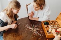 Girl in White Long Sleeve Shirt Holding Brown Wooden Brush