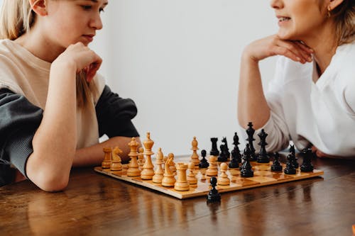 Women Playing Chess with Their Hands on Their Chin