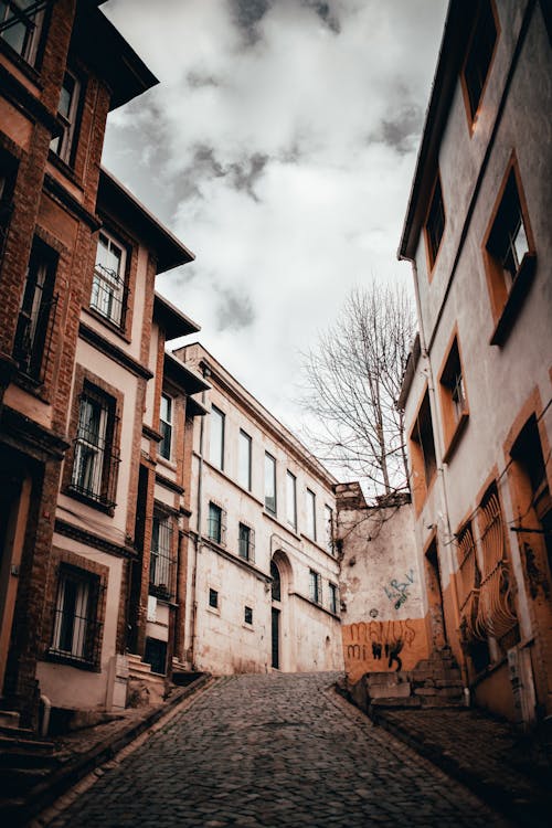 A Low Angle Shot of a Buildings Under the Cloudy Sky