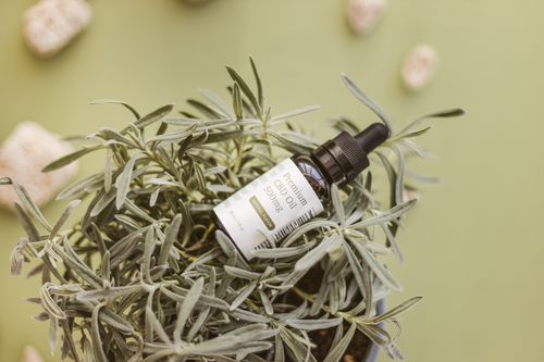 Free Close-up of CBD oil bottle nestled in fresh herbs, product shot. Stock Photo