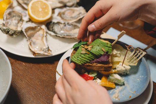 Delightful dinner scene featuring avocado toast and oysters with a lemon garnish.