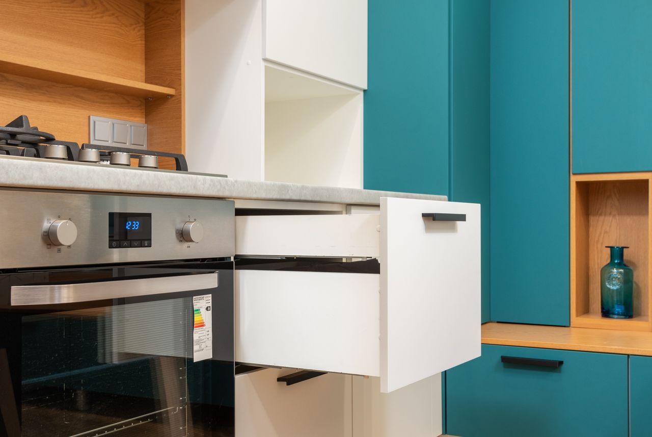 A pull-out shelf sliding from a base cabinet
