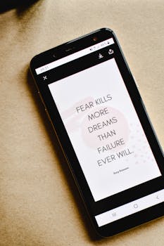 Close-up of a smartphone displaying an inspirational quote about fear and dreams.