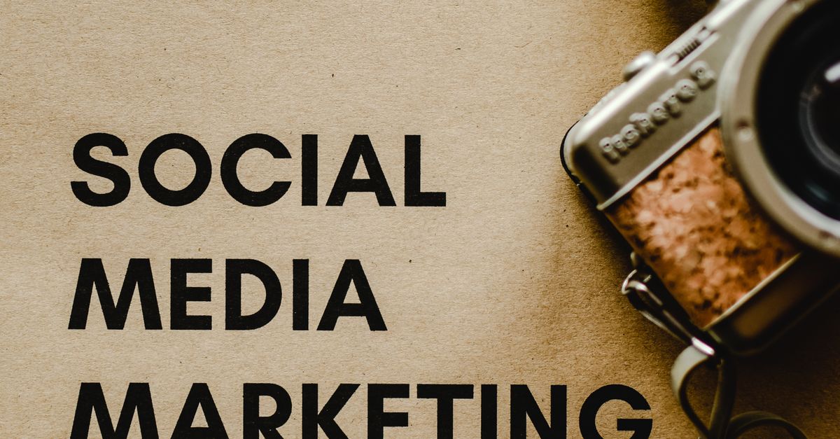 Close-up of a vintage camera next to a social media marketing concept text on a brown background.