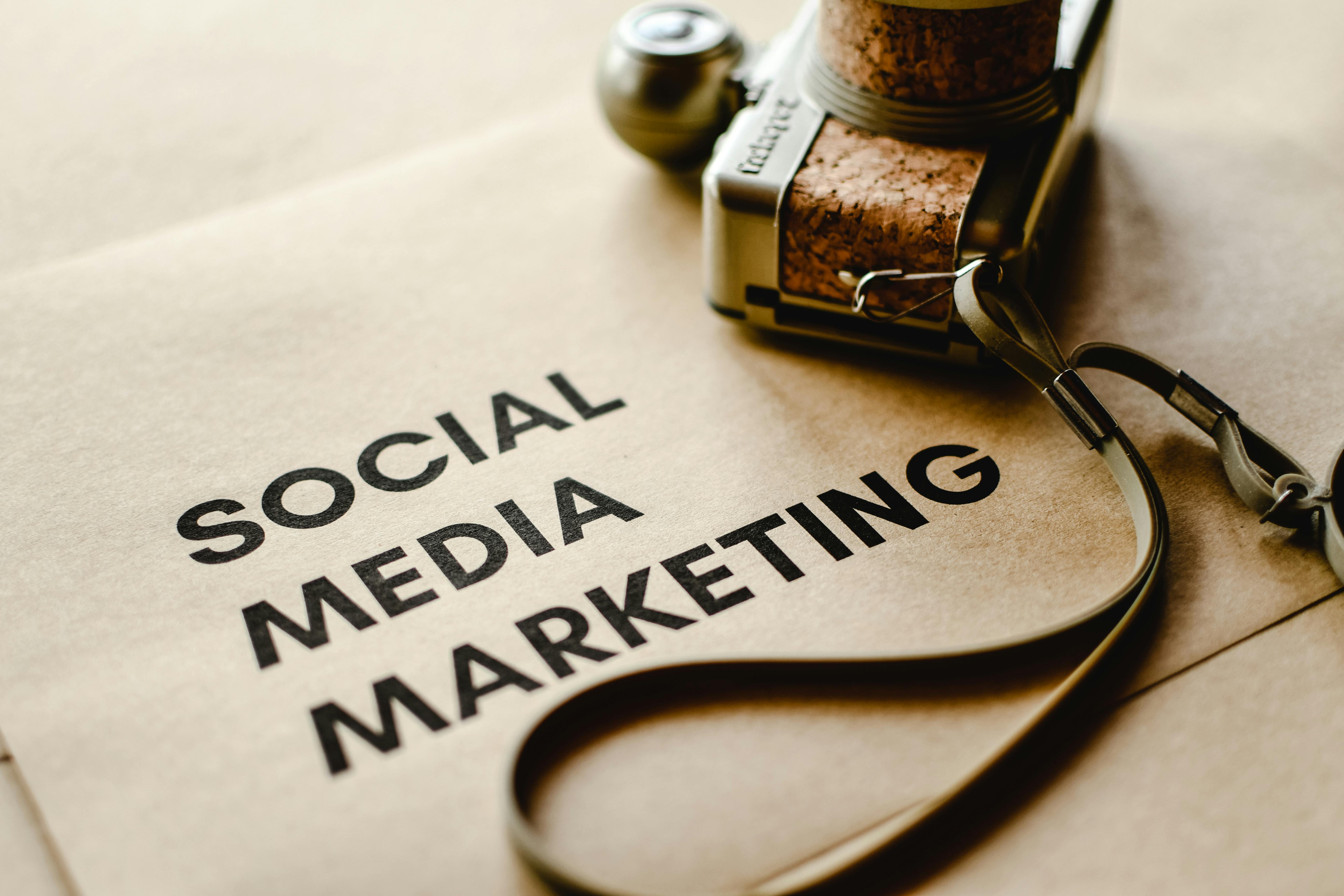 Close-up of a camera placed on brown paper with 'Social Media Marketing' text, emphasizing digital marketing themes.