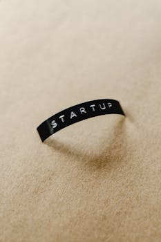 Close-up of a black label with 'STARTUP' text on a beige background, perfect for conceptual business themes.