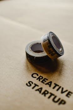 Close-up of measuring tapes on brown paper with 'creative startup' text, symbolizing innovation.