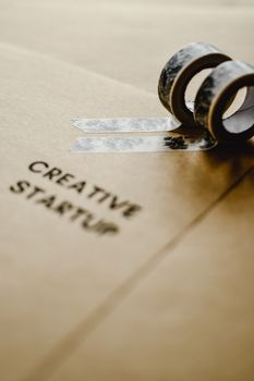 Brown paper with 'Creative Startup' text and decorative tapes for artistic projects.