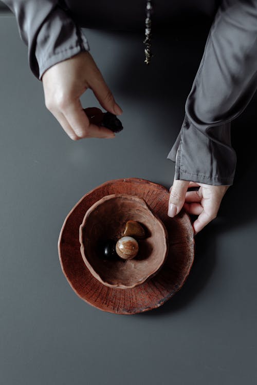 A Person Holding Brown Round Wooden Bowl