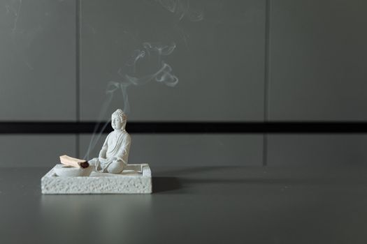 A Burning Palo Santo Beside the Buddha Statue
