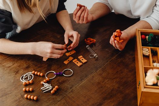 Hands of Woman and a Girl Playing with Objects on Wooden Table