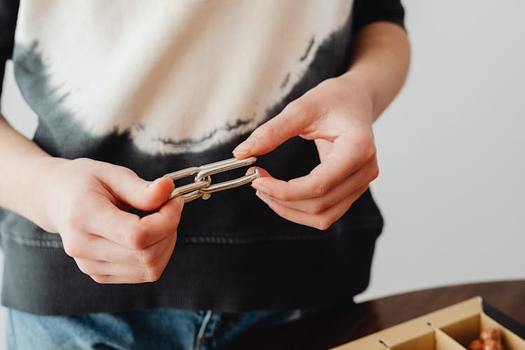 Close-up Of Person Holding Steel Puzzle