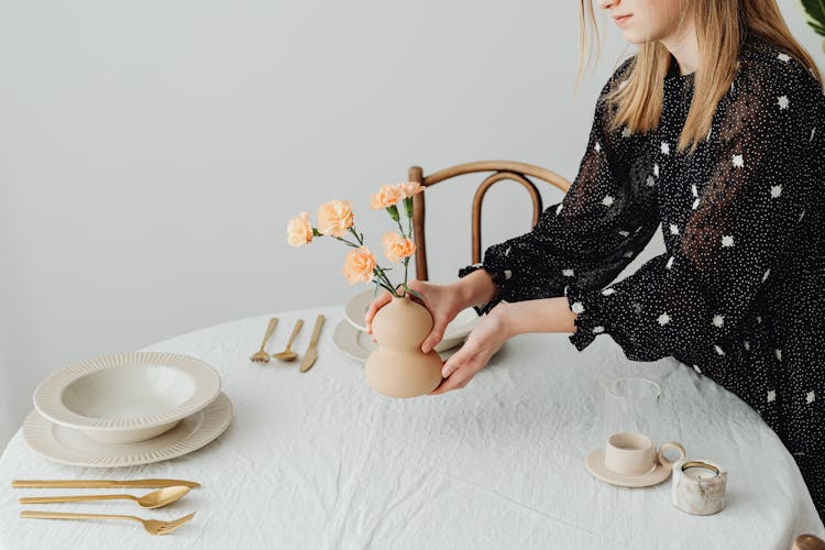 Woman Decorating Table With Minimalist Tableware