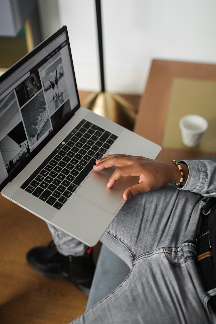 A Person Browsing Images In A Laptop