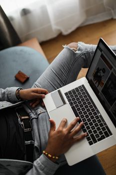 Casual wear individual shopping online with a laptop indoors.