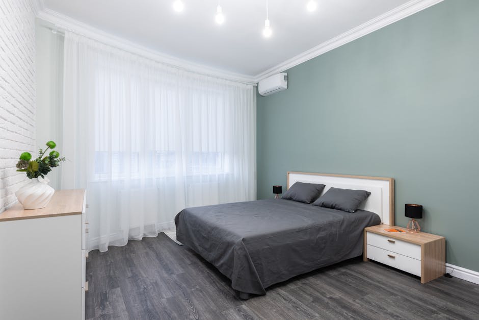 Modernes Schlafzimmer mit grauem, gepolstertem Kopfteil über einem 160 cm Bett