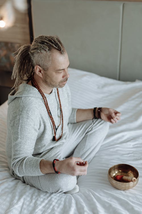 Focused Man Meditating on Bed