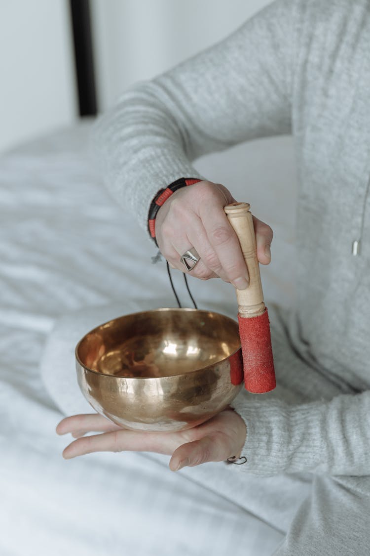 A Person Using A Tibetan Singing Bowl In Meditation