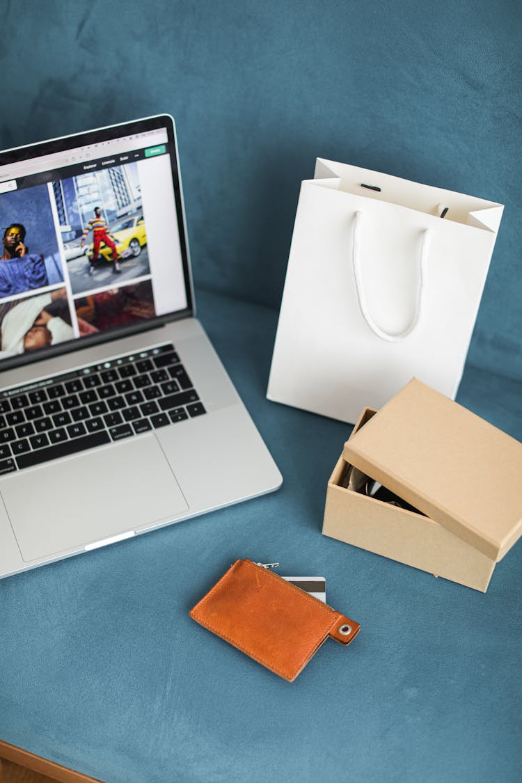  A Macbook Beside An Online Purchased Product In Box