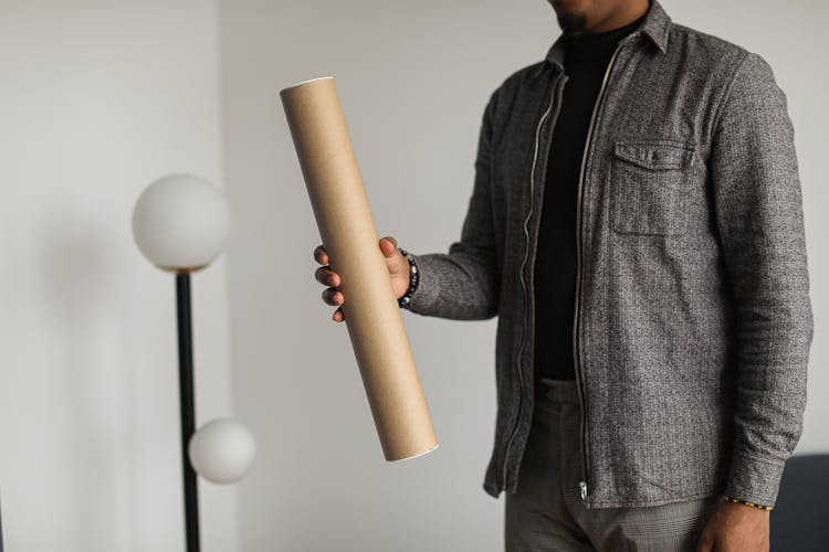 A Person Holding A Cardboard Tube