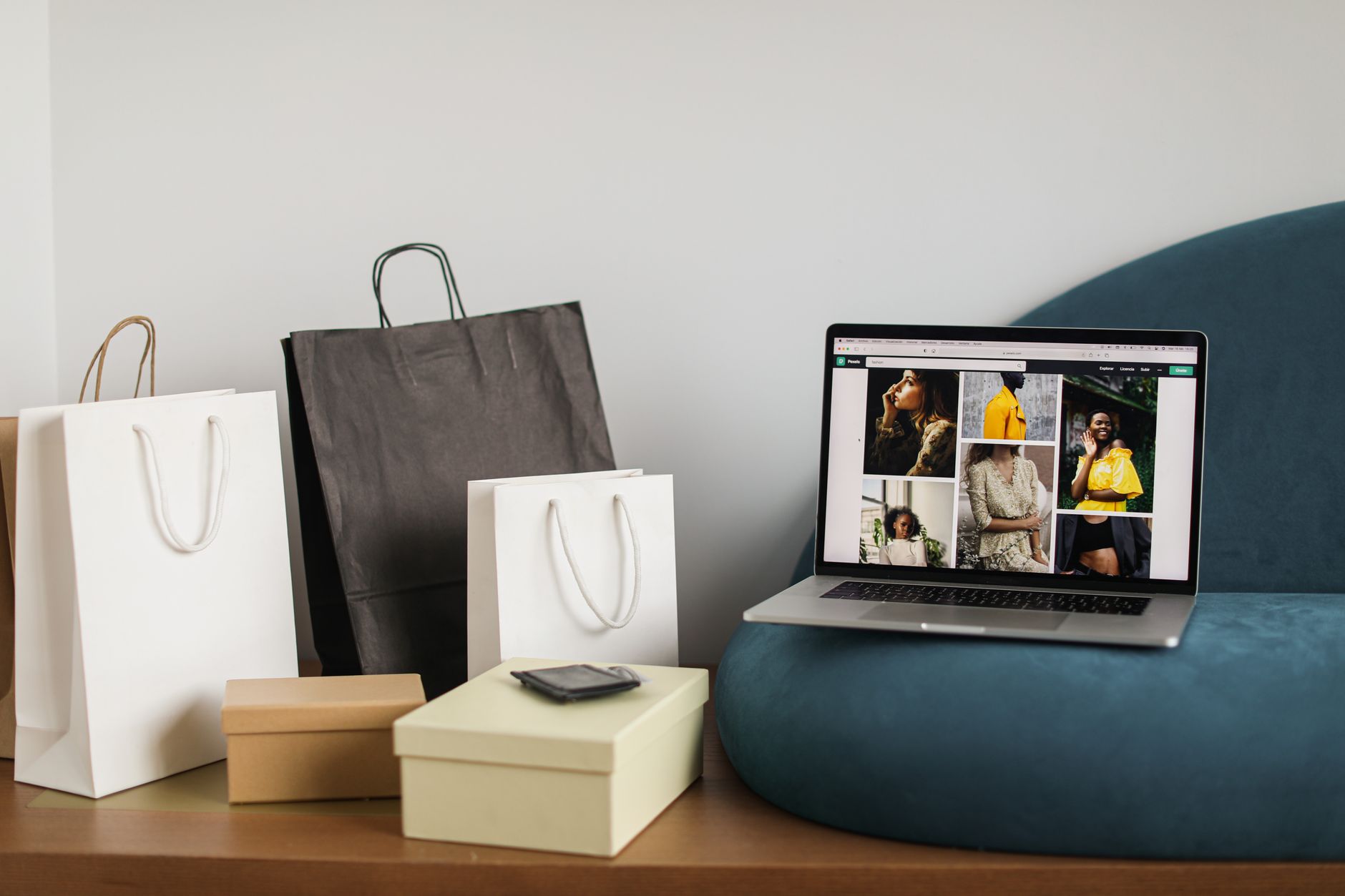 Ordinateur portable affichant un site e-commerce de mode avec des sacs shopping