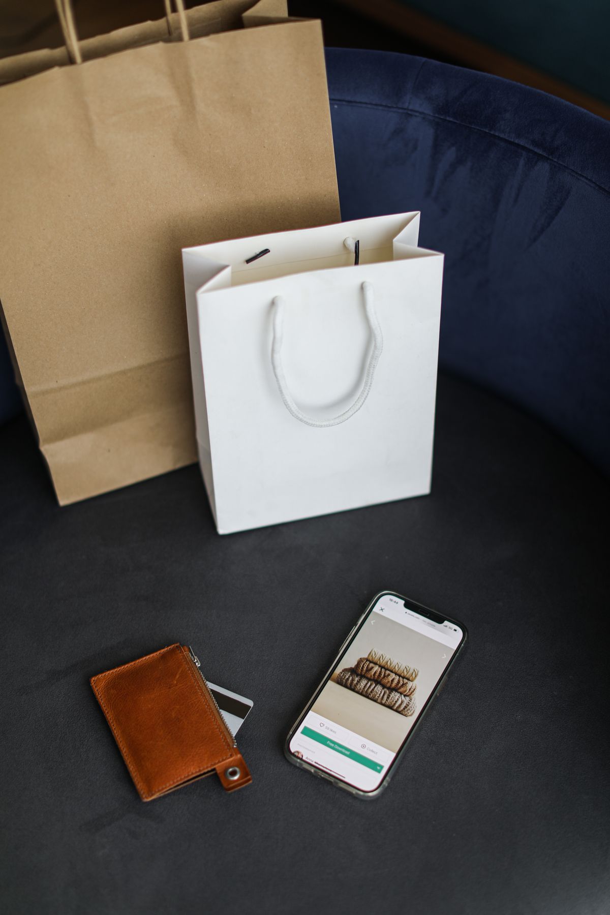 Shopping bags beside a smartphone browsing an online store, a snapshot of the everyday pay-in-4 spending fuelling BNPL growth in Canada