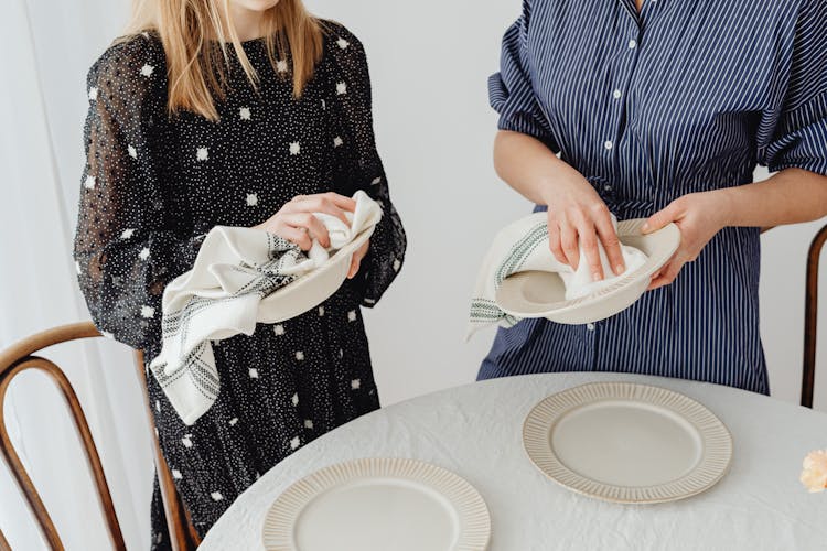 People Holding Ceramic Bowls While Wiping Using Table Napkins