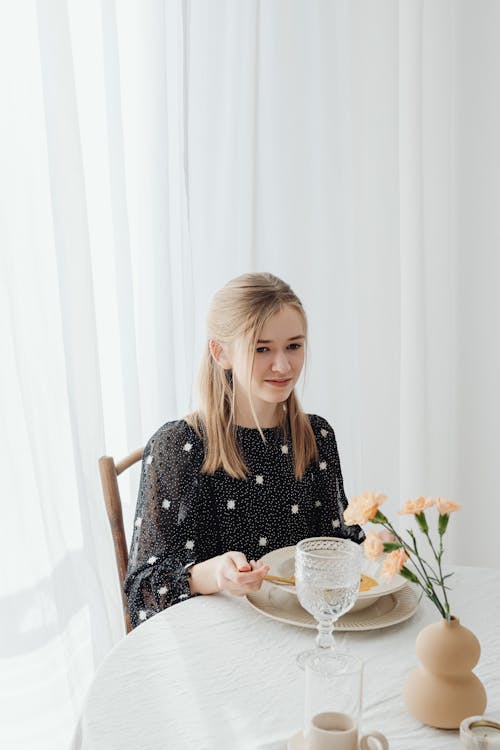Free A Woman Sitting by a Dining Table Stock Photo