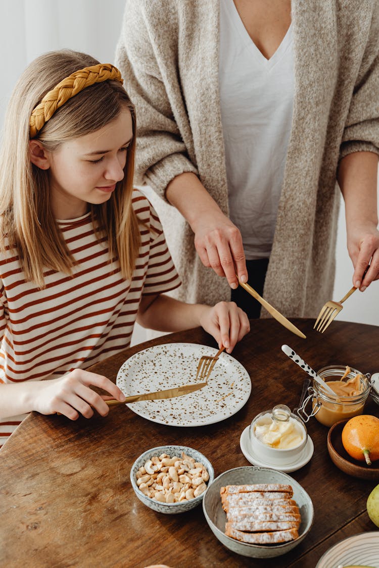 A High Angle Shot Of A Young Woman In Striped Shirt Holding A Spoon And Knife