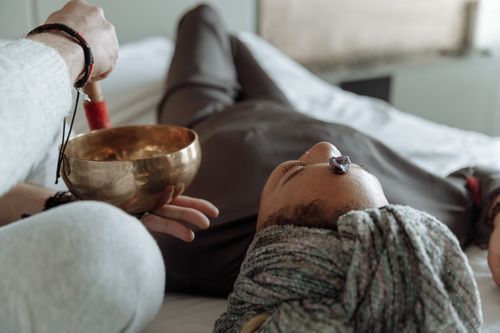Free A serene relaxation therapy session with a Tibetan singing bowl and crystal on forehead, promoting spiritual healing. Stock Photo