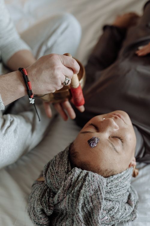 Free A woman experiencing spiritual healing through sound therapy and meditation indoors. Stock Photo