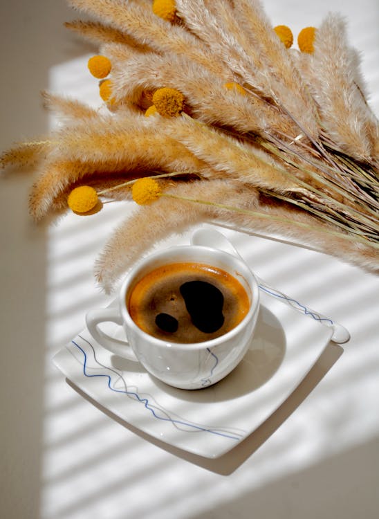black coffee near flowers on table