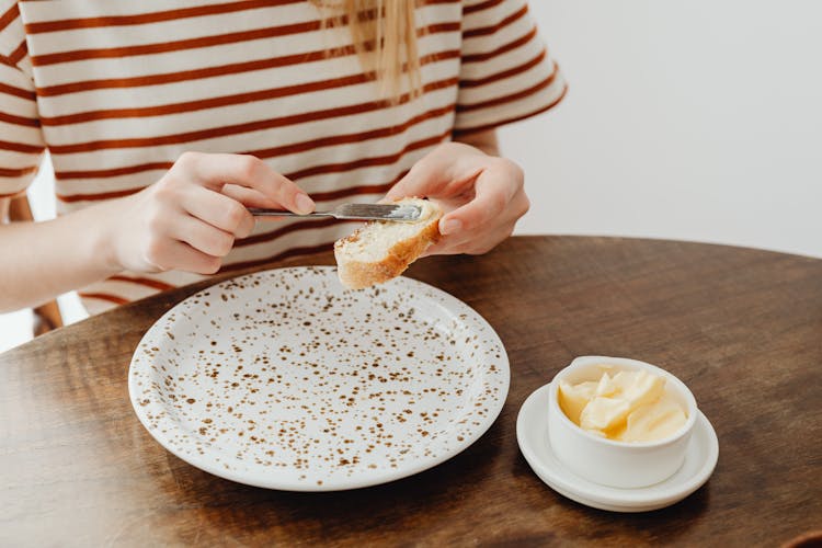 Person Spreading Butter On Sliced Bread