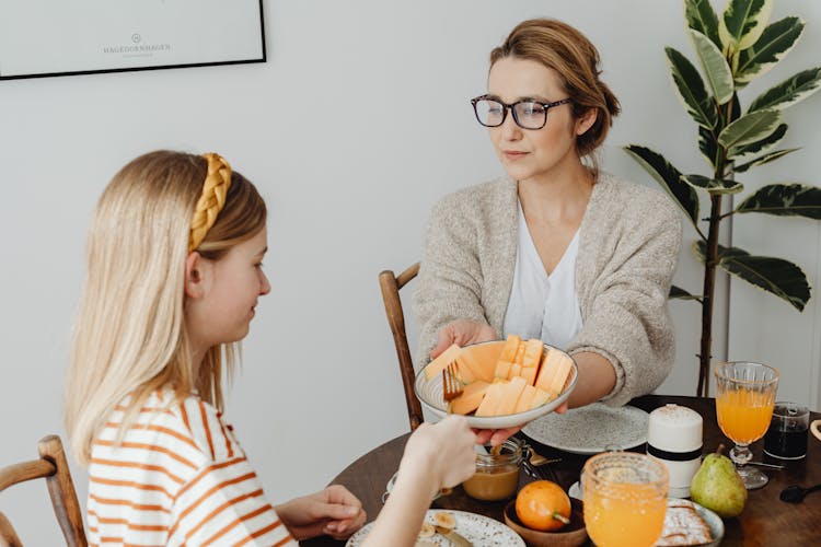 Mother And Daughter Taking Their Breakfast Together