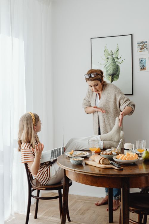 Free A mother scolding her teenage daughter in a cozy home setting with food on the table. Stock Photo