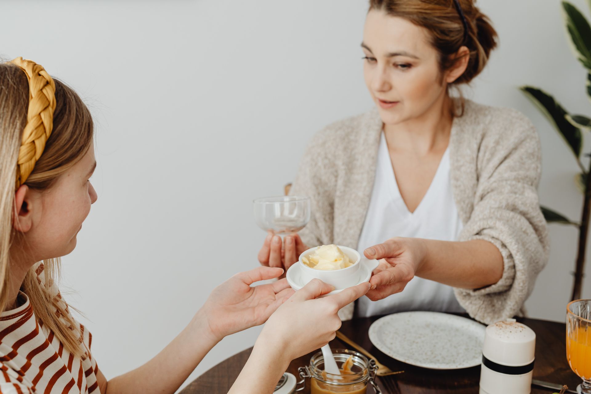 A mother shares a morning meal with her daughter in a cozy home setting, fostering family bonding.
